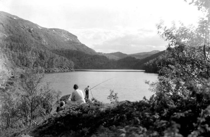 Et sort hvitt bildet av Kjelvikvatnet fra gamledager. Noen som fisker.