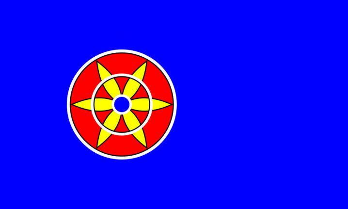 Kvensk flagg. Blå bakgrunn. Rundt rødt symbol med en gul blomst med blå kjerne.